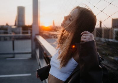 Frau mit langen Haaren von der Seite bei Sonnenuntergang